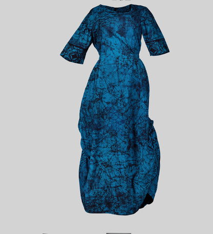 A flowing African wax print maxi dress showcasing the dress's elegant drape and movement. The 3/4 sleeves and fitted bodice create a flattering silhouette.